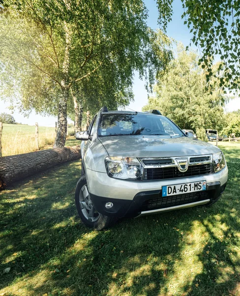 Dacia Duster SUV en verde fild montañas francesas bajo el árbol — Foto de Stock