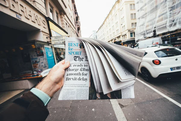 Pria yang memegang surat kabar Inggris The Daily Telegraph — Stok Foto
