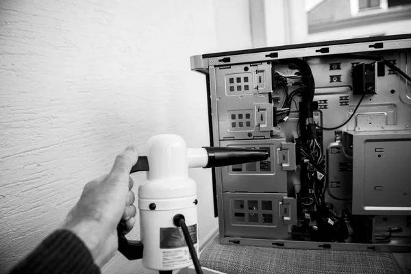 Uomo che si prepara a pulire caso computer con pulitore di polvere — Foto Stock