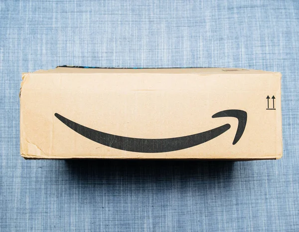 Neuer Amazon Prime Paketkarton auf textilem Hintergrund — Stockfoto