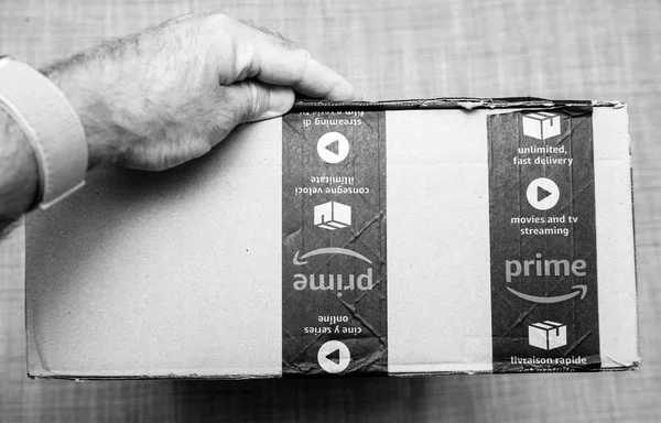 Man kézben tartó kartondoboz Amazon Prime emblémát — Stock Fotó