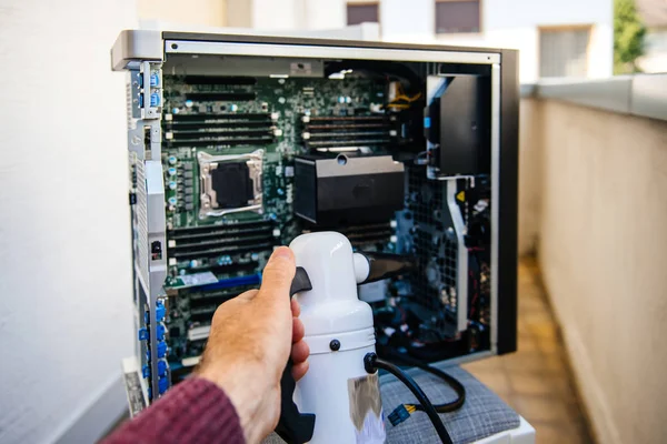 Man preparing to clean computer case with dust cleaner