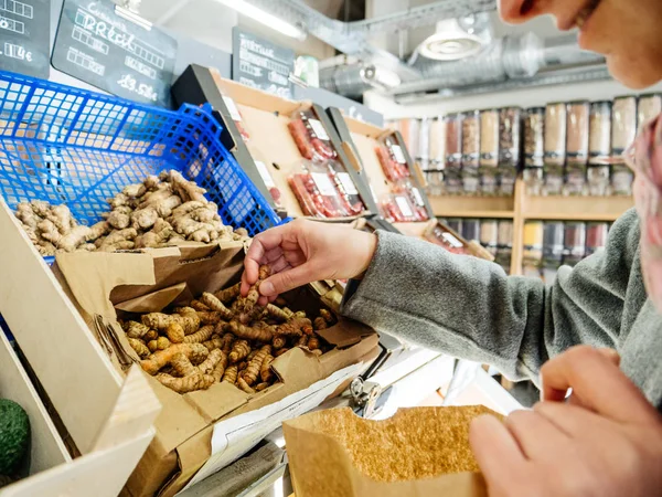 Mujer de compras para fresco curcuma cúrcuma rizomas supermercado — Foto de Stock