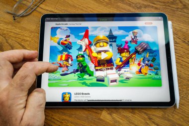 İpad profesyonel tablet Apple Web sitesinde Arcade aboneliği hakkında okuma kullanan adam