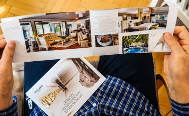 Kıdemli adam gelecekteki nehir gezisi tatil hakkında broşür okuma