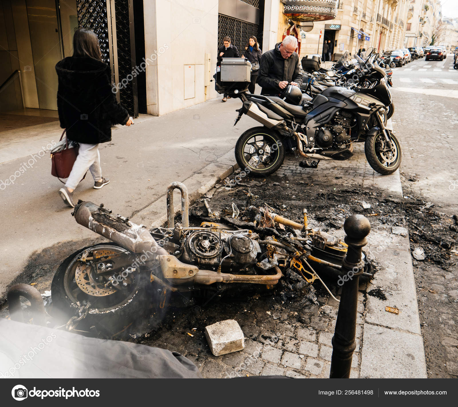 Pedestrians walking near burned luxury sport motorcycles – Stock
