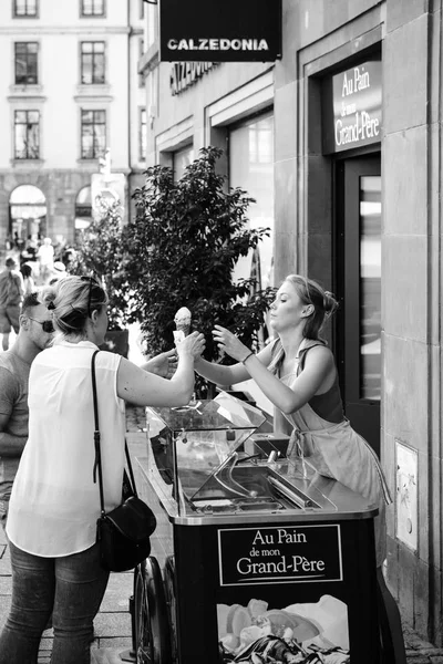 Young blonde woman preparing ice-cream cone for client — Stock Photo, Image