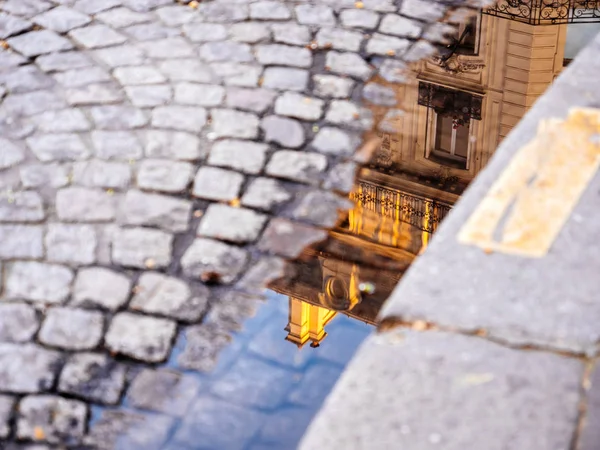 Puddle in central Paris cobblestone reflection house building — Stock Photo, Image