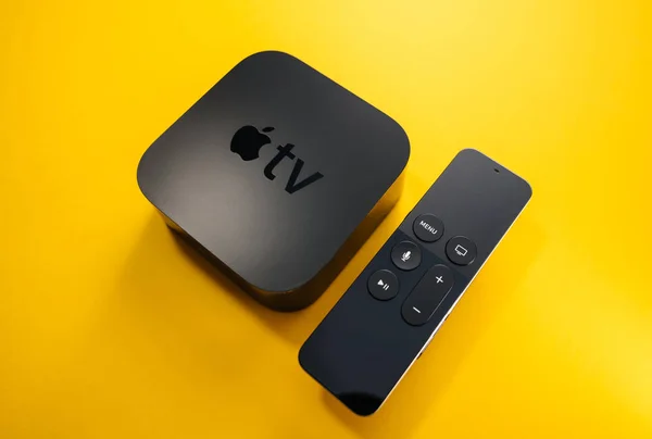 Apple TV 4K ze zdalnym sterowaniu wyizolować żółte tło — Zdjęcie stockowe
