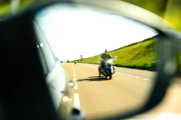 View of following motorcyclist on the highway rear view mirror — Stock Photo, Image