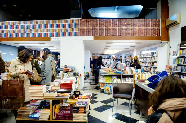 Personas dentro de la librería en Atenas por la noche —  Fotos de Stock