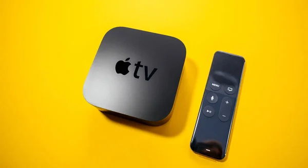 Apple TV 4k med fjärrkontroll isolerar gul bakgrund — Stockfoto