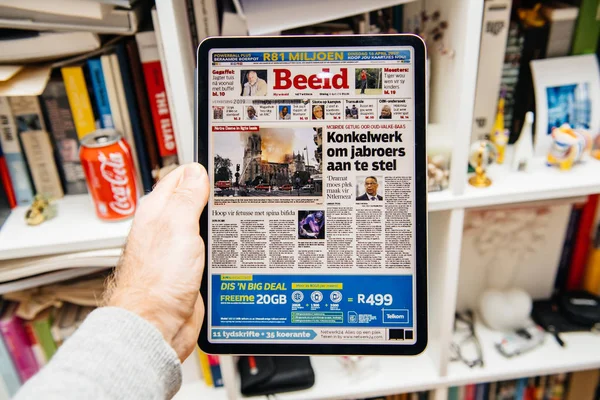 Man reading on iPad Pro about Notre-Dame de Paris fire — Stock Photo, Image