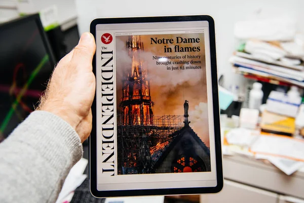 Man reading on iPad Pro about Notre-Dame de Paris fire — Stock Photo, Image