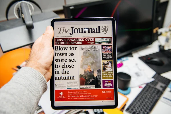 Man reading on iPad Pro about Notre-Dame de Paris fire — Stock Photo, Image