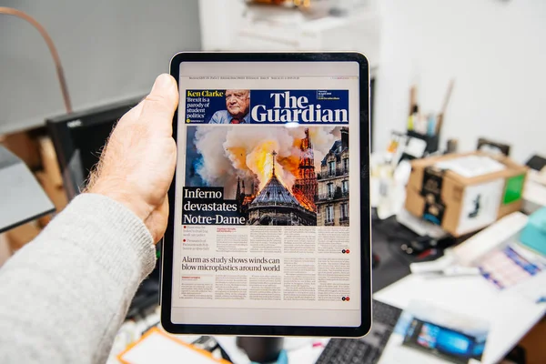 Man reading on iPad Pro about Notre-Dame de Paris fire — Stock Photo, Image