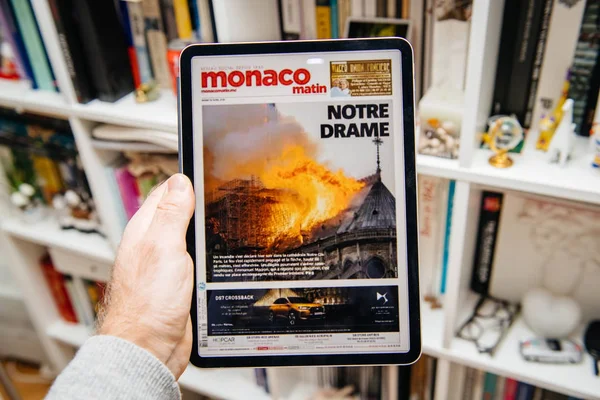 ノートルダム・ド・パリ火災についてiPad Proで読んでいる男 — ストック写真