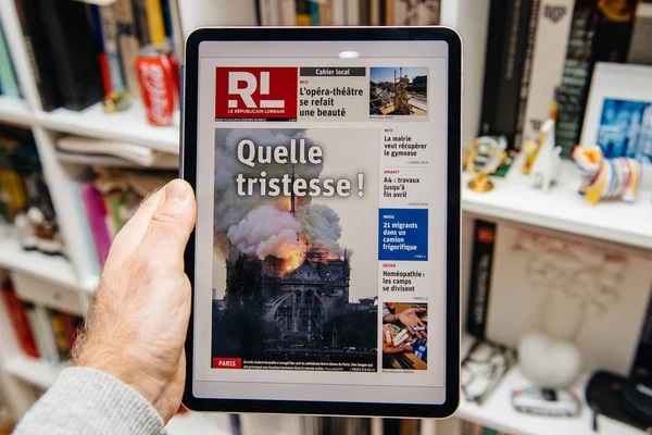 Hombre leyendo en iPad Pro sobre el incendio de Notre-Dame de Paris — Foto de Stock