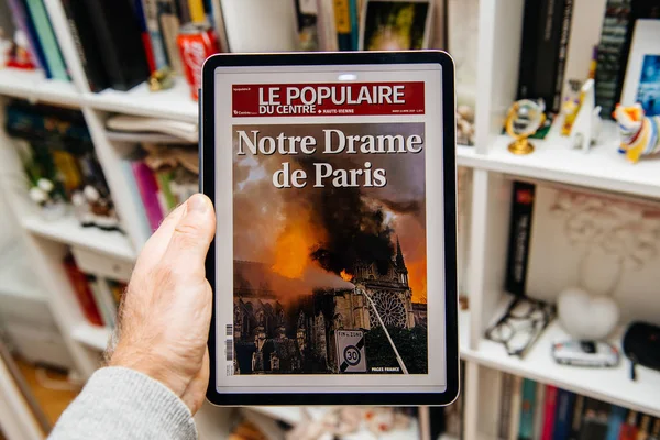 Czytanie człowieka na iPadzie Pro o ogień Notre-Dame de Paris — Zdjęcie stockowe