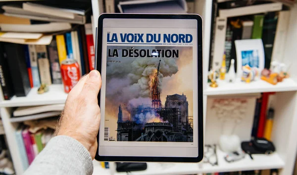 Man reading on iPad Pro about Notre-Dame de Paris fire — Stock Photo, Image