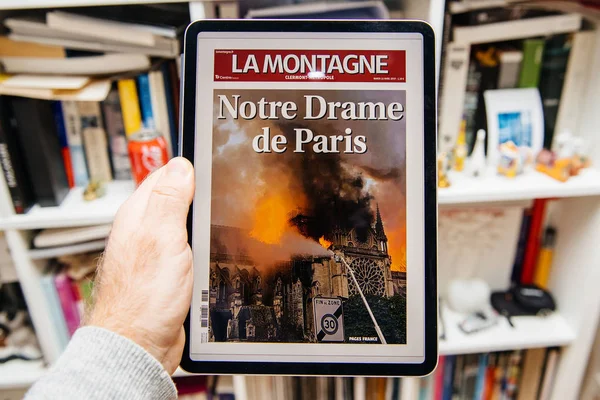 Mies lukee iPad Prossa Notre-Dame de Paris tulipalosta — kuvapankkivalokuva