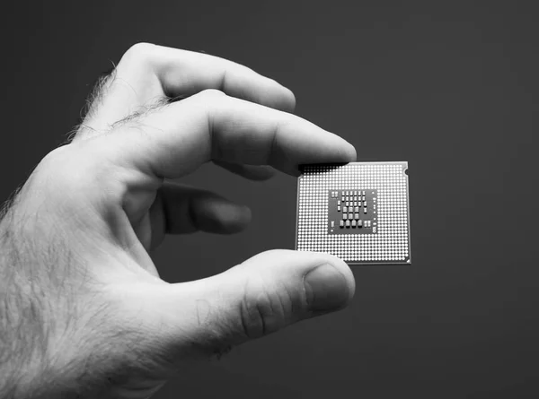 Mužská ruka držící CPU centrální procesorové jednotky šedé pozadí — Stock fotografie