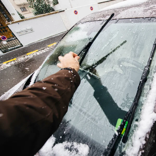 Man cleaning car windshields wipers before driving