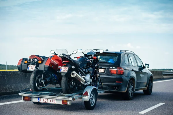 BMW colorido suv X5 dirigindo rápido na estrada francesa com reboque — Fotografia de Stock