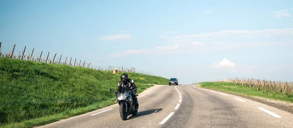 Motorcyclist being followed by black SUV on road — Stock Photo, Image