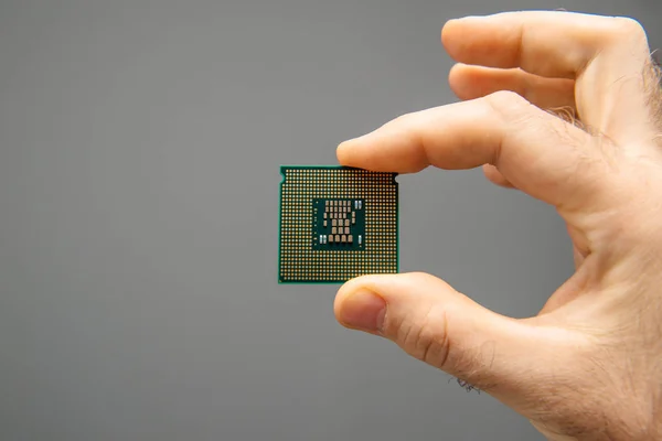 Άνθρωπος κράτημα χέρι CPU κεντρική μονάδα επεξεργασίας γκρι φόντο — Φωτογραφία Αρχείου