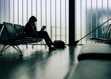 ince dizüstü bilgisayar üzerinde boş havaalanı terminalinde çalışan iş kadını 