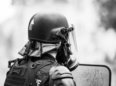 Gaz lı gaz maskesi takan polis memurunun arka görünümü