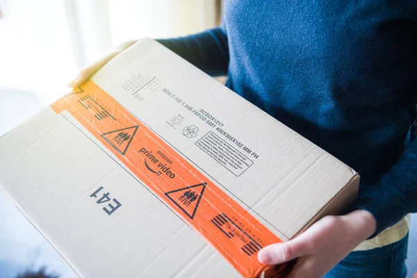 Woman with Amazon Prime Video logotype on cardboard box — Stock Photo, Image