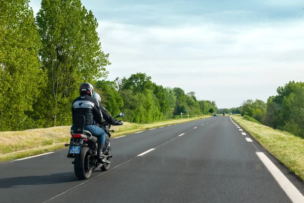 Team of motorcyclists driving fast on French rural highway — Stock Photo, Image