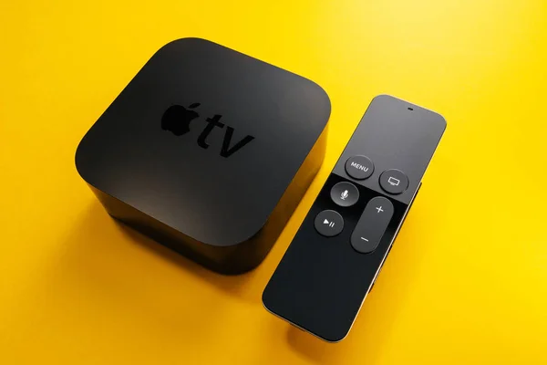 Ny Apple TV 4K med fjärrkontroll isolera gul bakgrund — Stockfoto