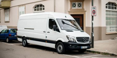 Beyaz Mercedes-Benz Sprinter minibüsü park halinde.