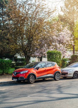 Kırmızı Renault Captur Suv güneşli bir sokakta park 