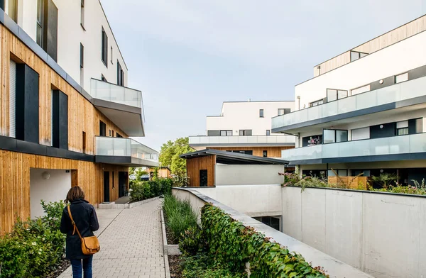 Bakifrån av kvinnan in i territoriet i modern bostadsrätts byggnad — Stockfoto