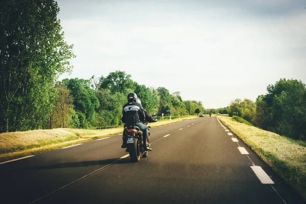 Team of motorcyclists driving fast on French rural highway — Stock Photo, Image