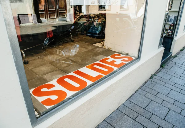 View of Soldes Sales sing in in the fashion store glass showcase with BMW mini car parked in the street — Stock Photo, Image