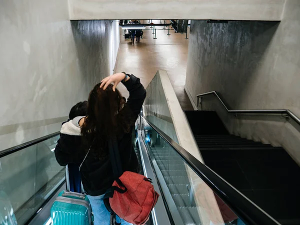 Meninas jovens descendo na escada rolante do aeroporto para o terminal Aeroporto de Lisboa — Fotografia de Stock