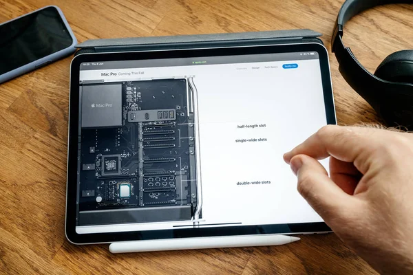 Man lezen op iPad Pro start Mac Pro Workstation PCI-uitbreidingskaarten — Stockfoto
