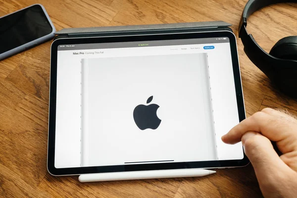 Hombre leyendo en el iPad Pro lanzar Mac Pro estación de trabajo, logotipo, insignia , — Foto de Stock