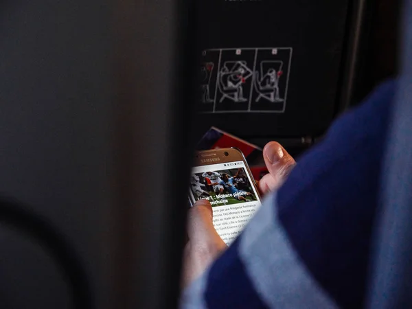 Frau liest Nachrichten auf Smartphone im Flugzeug per WLAN — Stockfoto