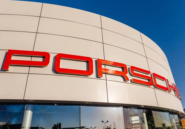 Araba bayiliğinin ön cephesinde büyük Porsche logosu — Stok fotoğraf