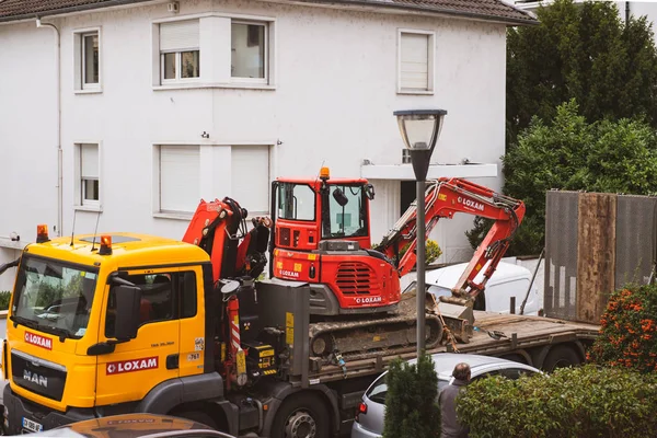 Loxam renting service man truck transport graafmachine — Stockfoto