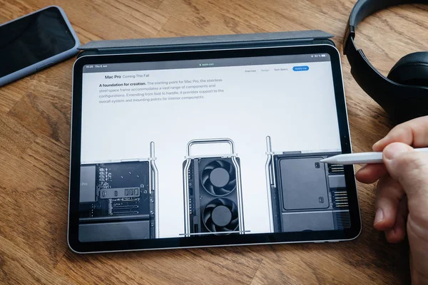 Lettura uomo su iPad Pro lancio Mac Pro workstation — Foto Stock