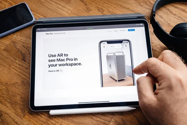 Человек, читающий на iPad Pro, запускает рабочую станцию Mac Pro — стоковое фото