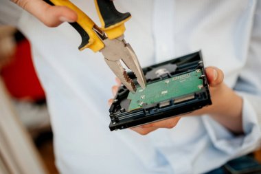 Kadın It bilgisayar tamir Bu kadın sarı metal pliers kullanarak