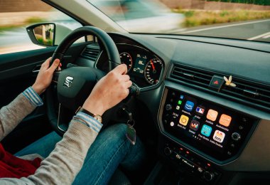 Kadın, gösterge panelinde Apple Car ile hızlı araba kullanıyor.